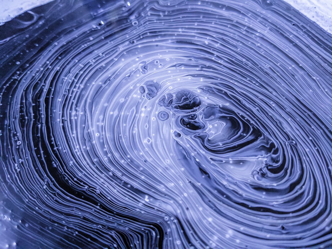 This experimental painting features swirls of black, grey, purple, and white paints. As the paints began to dry, I took this closeup.

The technique I use to create this kind of paint texture is called “fluid art,” and it relies on mixing a variety of mediums into acrylic paints to influence how they interact. I’ll use materials like glue, isopropyl alcohol, liquid silicone, and a butane torch.